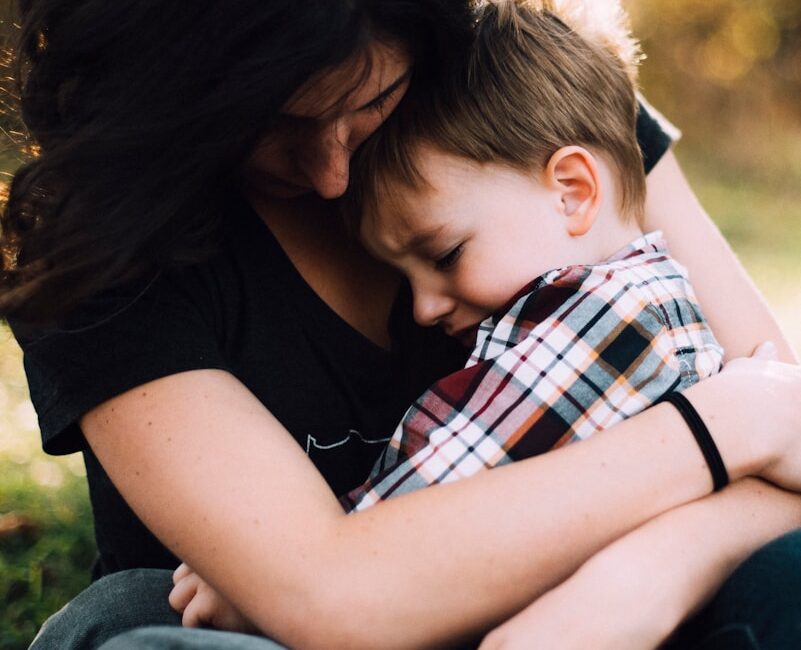 woman hugging boy on her lap